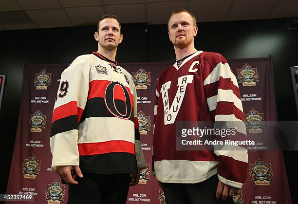 Jason Spezza of the Ottawa Senators and Henrik Sedin the Vancouver Canucks pose with NHL Heritage Classic jerseys during an official announcement at...