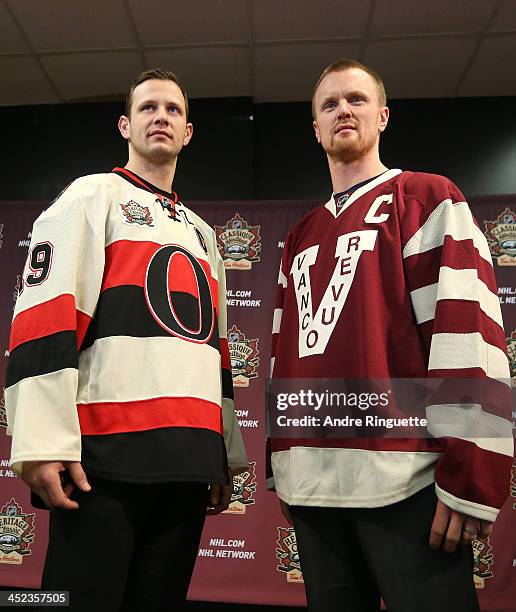 Jason Spezza of the Ottawa Senators and Henrik Sedin the Vancouver Canucks pose with NHL Heritage Classic jerseys during an official announcement at...