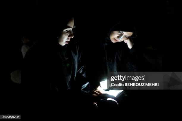 Iranian Shiite Muslim women pray in Tehran during the early hours of July 19, 2014 to commemorate the death of Imam Ali bin Abi-Taleb, assassinated...