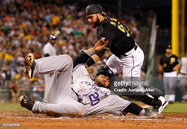Wilin Rosario of the Colorado Rockies score on a RBI single in the sixth inning against Russell Martin of the Pittsburgh Pirates during the game at...