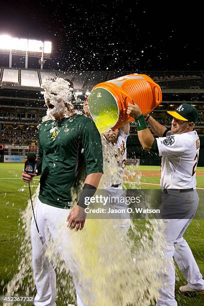 Josh Donaldson of the Oakland Athletics has Gatorade poured on him by Stephen Vogt and Derek Norris after hitting a walk off three run home run...