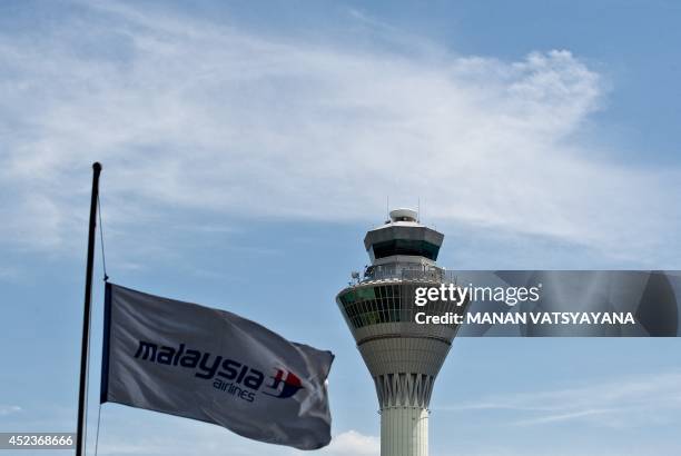 Malaysia Airlines flag flies at half-mast in the back drop of an Air-Traffic Control tower at Kuala Lumpur International Airport in Sepang on July...