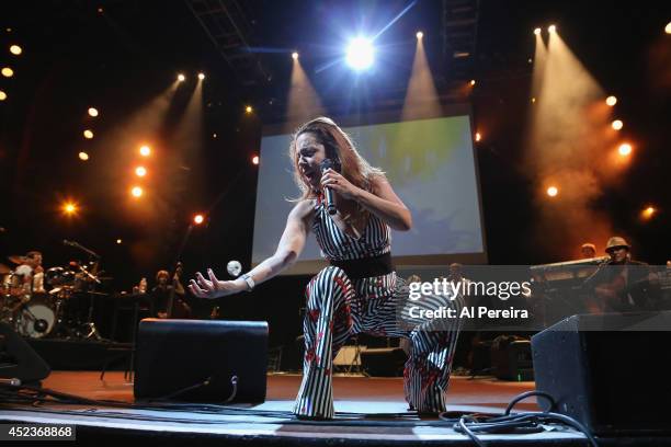 Bebel Gilberto catches jewlery tossed up by a fan when she performs during 2014 Celebrate Brooklyn! at the Prospect Park Bandshell on July 18, 2014...