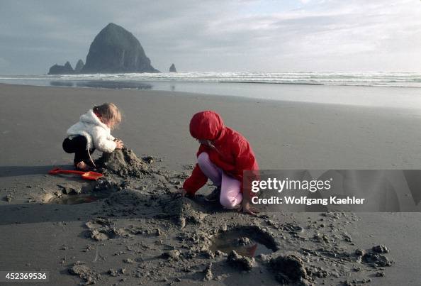 USA, Oregon, Cannon Beach, Children Playing In Sand On Beach USA, Oregon, Cannon Beach, Children Playing In Sand On Beach