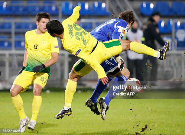 Anzhi Makhachkala's midfielder Ilya Maksimov and Nigerian defender Dele Adeleye vie with FC Sheriff Tiraspol's goalkeeper Vjekoslav Tomic during...