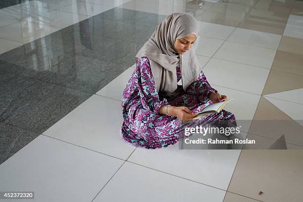 School friend of Nur Shazana Mohamed, one of the victims in the Malaysia Airlines flight MH17 recites quranice verses during a prayer for her on July...