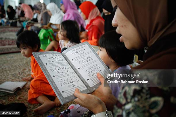 School friends of Nur Shazana Mohamed, one of the victims in the Malaysia Airlines flight MH17 recites quranice verses during a prayer for her on...