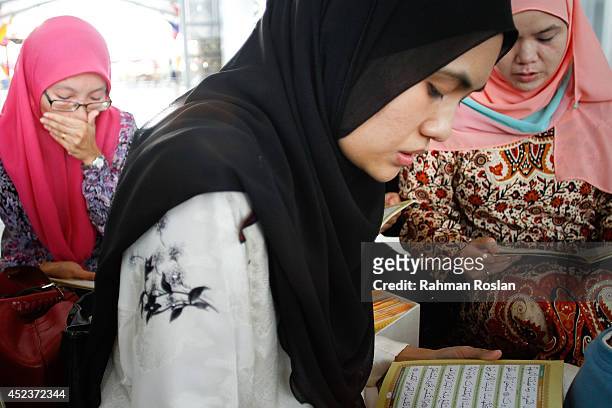 School friends of Nur Shazana Mohamed, one of the victims in the Malaysia Airlines flight MH17 recites quranice verses during a prayer for her on...