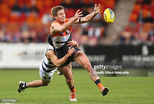 Adam Tomlinson of the Giants is tackled by Mathew Stokes of the Cats during the round 18 AFL match between the Greater Western Sydney Giants and the...