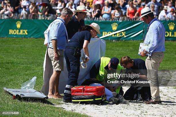 Lucy Jackson of New Zealand rides on Willy Do and is treated after falling down during the DHL Price Cross Country Test at Aachener Soers on July 19,...