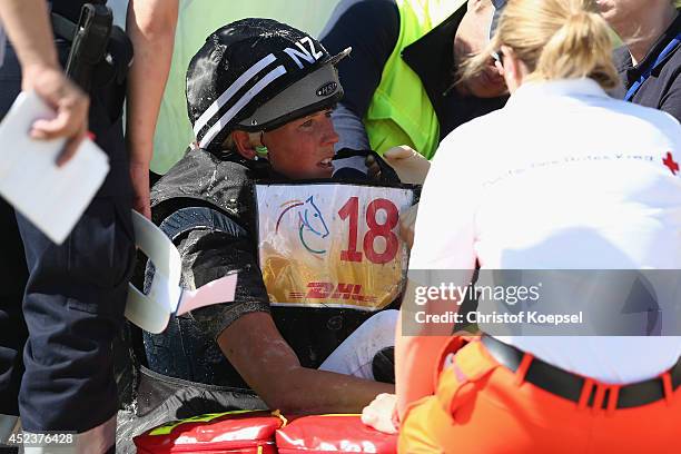 Lucy Jackson of New Zealand rides on Willy Do and is treated after falling down during the DHL Price Cross Country Test at Aachener Soers on July 19,...