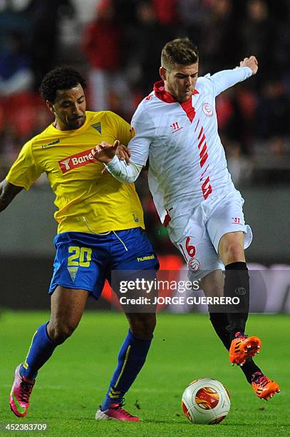 Estoril's forward Carlitos vies with Sevilla's defender Alberto Moreno during the UEFA Europa League football match Sevilla FC vs Estoril Praia at...