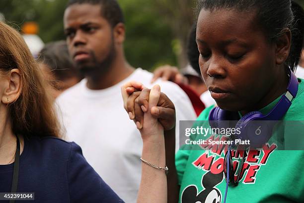 People participate in a prayer during a demonstration against the death of Eric Garner after he was taken into police custody in Staten Island on...