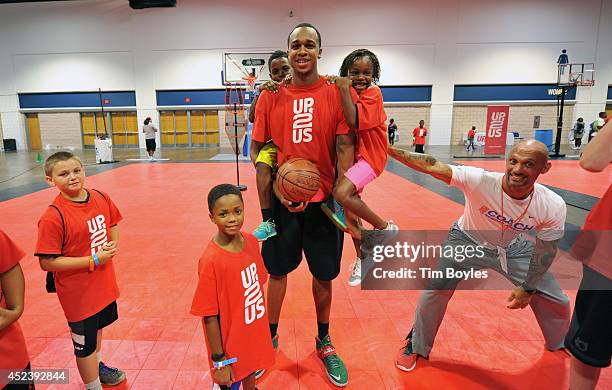 Students hang on Milwaukee Bucks forward John Henson at the John Henson Experience benefitting Up2Us at the Tampa Bay Youth Sports Expo on July 19,...