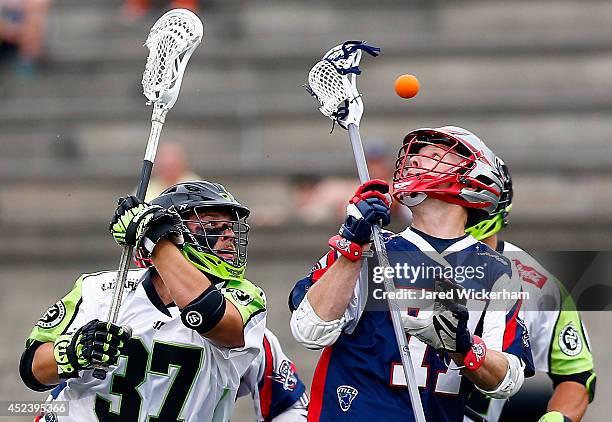 Kyle Sweeney of the Boston Cannons and Jerry Ragonese of the New York Lizards reach for a loose ball in the first half during the game at Harvard...