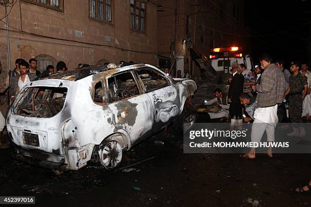 Investigators from the Criminal Investigation Department inspect the wreckage of a car belonging to the Deputy Director General of Sana'a...