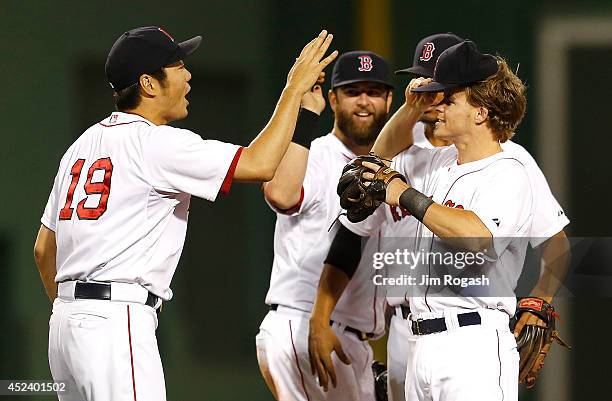 Koji Uehara of the Boston Red Sox celebrates with Mike Napoli and Brock Holt after defeating the Kansas City Royals, 2-1, at Fenway Park on July 19,...