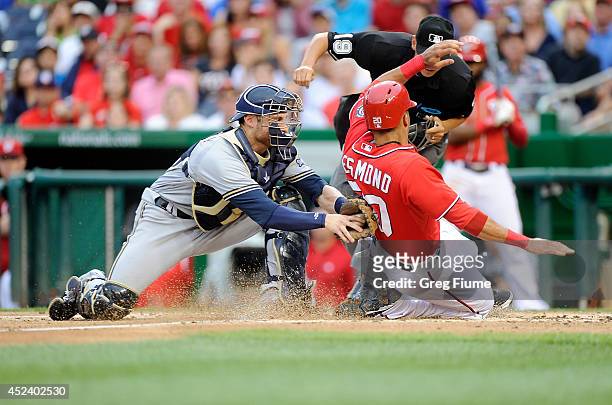 Ian Desmond of the Washington Nationals is tagged out at home plate in the first inning by Jonathan Lucroy of the Milwaukee Brewers at Nationals Park...