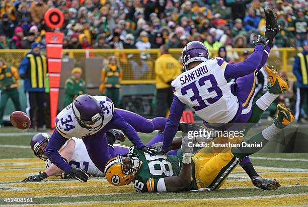 Andrew Sendejo and Jamarca Sanford of the Minnesota Vikings break up pass in the end zone intended for Brandon Bostick of the Green Bay Packers at...