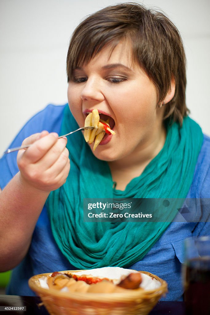 Young woman in cafe eating fries