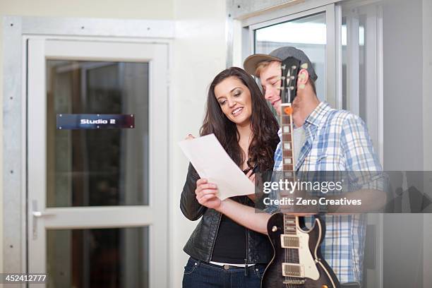 young musicians looking at sheet music - score 2 stock pictures, royalty-free photos & images