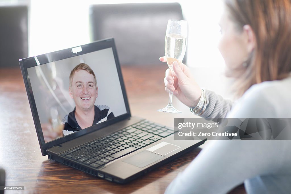 Woman toasting husband using video call