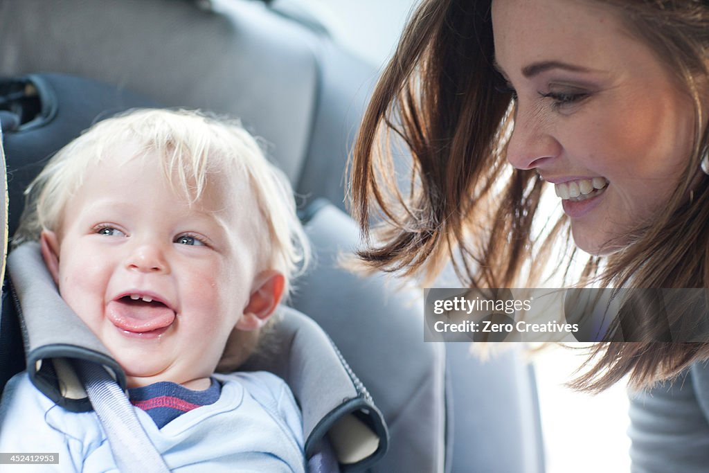 Mother with baby son in back seat of car
