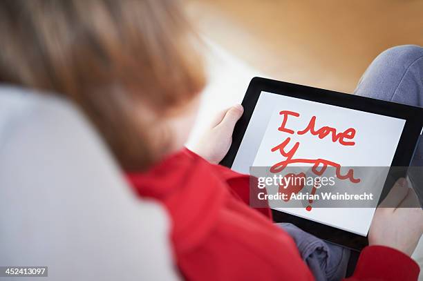 rear view of boy holding tablet saying 'i love you - its a boy frase inglese foto e immagini stock