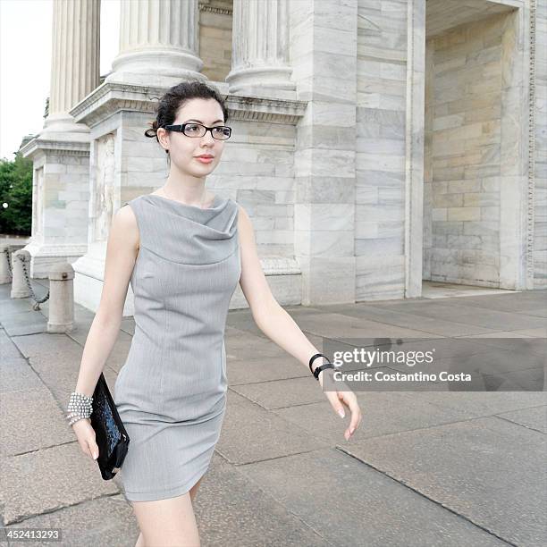 smart young woman walking along pavement - striding stock pictures, royalty-free photos & images