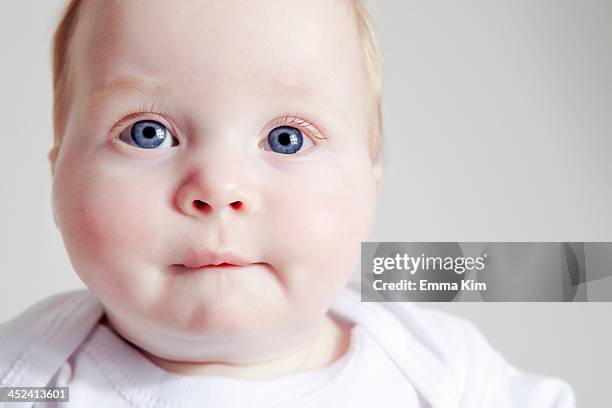 close up of baby girl biting lip - biting lip stock pictures, royalty-free photos & images