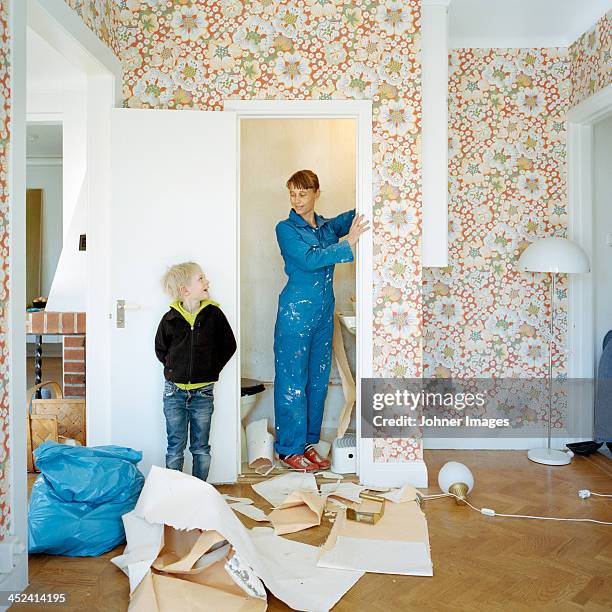 mother and son renovating room - casser mur photos et images de collection