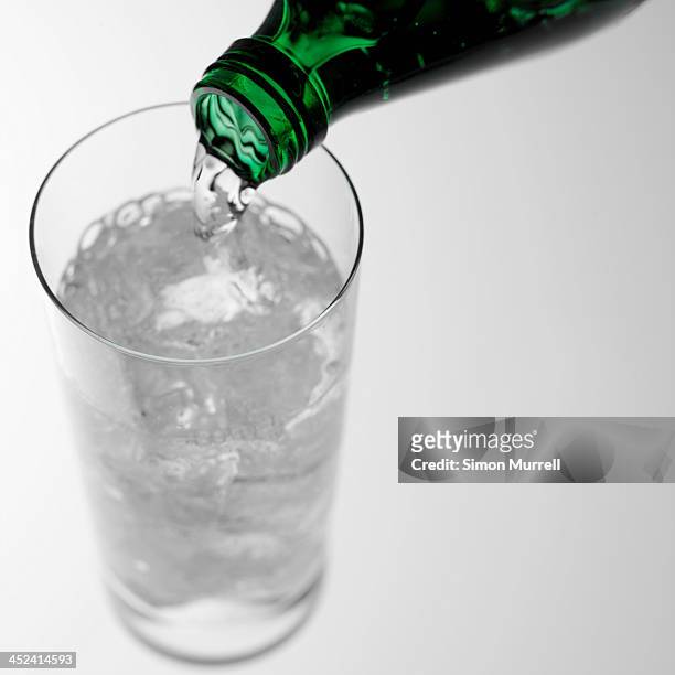 pouring sparkling water into glass - sparkling water glass stock-fotos und bilder