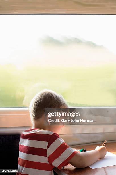 young boy drawing on train - norman window fotografías e imágenes de stock