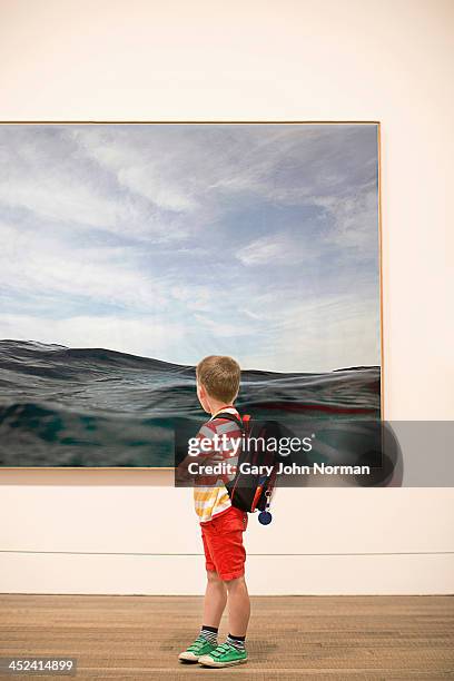 young boy looking at picture in gallery - children art show stock pictures, royalty-free photos & images