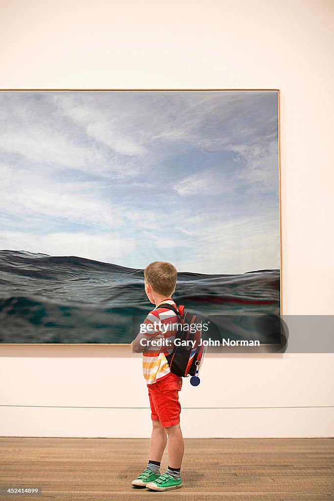 Young boy looking at picture in gallery