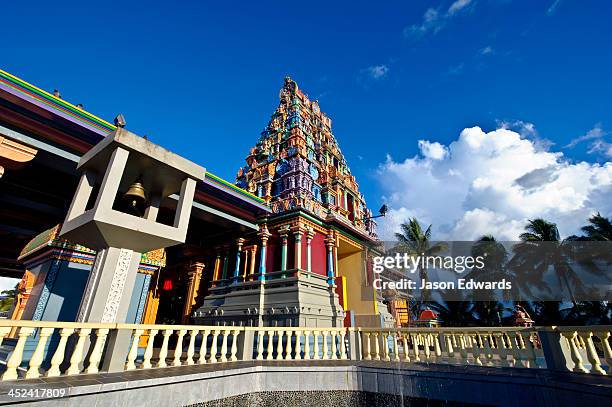 a brass bell and colorful statues adorn a hindu temple. - nadi - fotografias e filmes do acervo