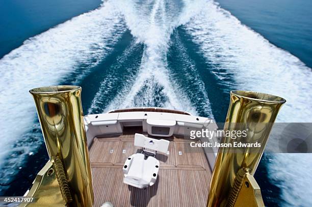 brass fishing rod holders on a luxury speed boat deep sea fishing. - poupe photos et images de collection