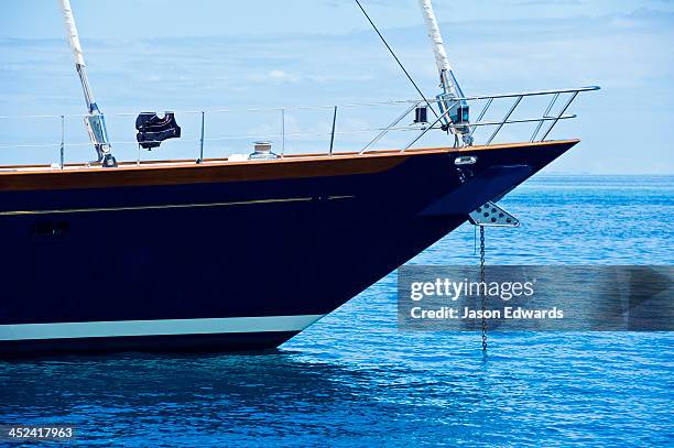 the bow of a luxury yacht anchored in a clear blue calm lagoon. - proa fotografías e imágenes de stock