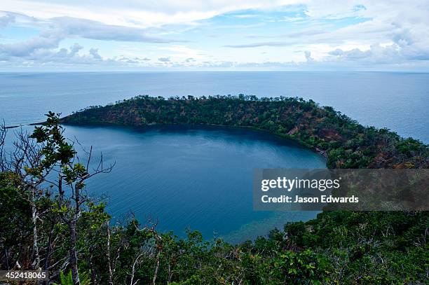 the forested slopes of an extinct volcano caldera rise from the ocean. - fiji jungle stock pictures, royalty-free photos & images