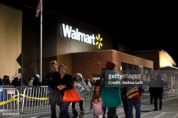 Customers wait in line to enter Wal-Mart Thanksgiving day on November 28, 2013 in Troy, Michigan. Black Friday shopping began early this year with...
