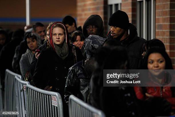 Customers wait in line to enter Wal-Mart Thanksgiving day on November 28, 2013 in Troy, Michigan. Black Friday shopping began early this year with...