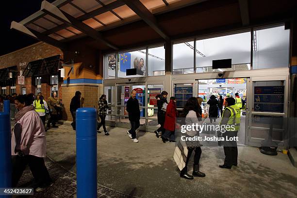 Customers enter Wal-Mart Thanksgiving day after waiting in line on November 28, 2013 in Troy, Michigan. Black Friday shopping began early this year...