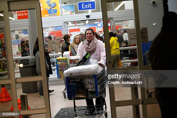 Customers leave Wal-Mart with their purchased items Thanksgiving day on November 28, 2013 in Troy, Michigan. Black Friday shopping began early this...