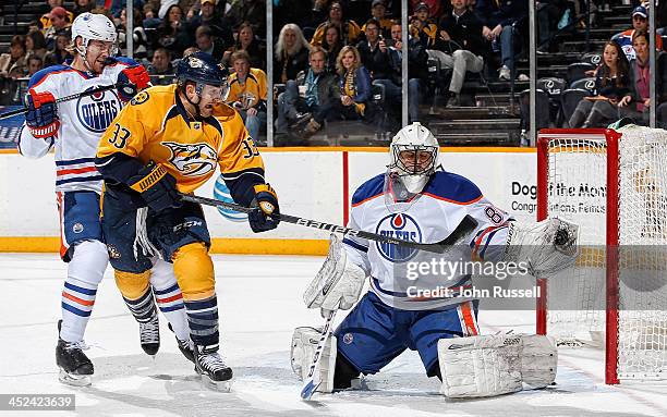 Ilya Bryzgalov of the Edmonton Oilers makes the save against Colin Wilson of the Nashville Predators as Oilers Jeff Petry defends at Bridgestone...