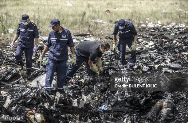 Ukrainian State Emergency Service employees search for bodies amongst the wreckage at the crash site of Malaysia Airlines Flight MH17, near the...