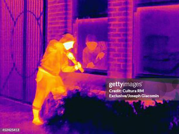 thermal photograph of a burglar breaking into a house - infrared stockfoto's en -beelden