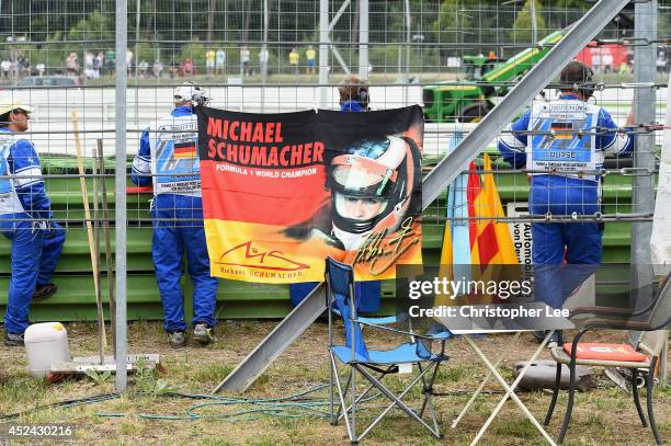 Race Stewards tie up a Michael Schumacher flag during the German Grand Prix at Hockenheimring on July 20, 2014 in Hockenheim, Germany.