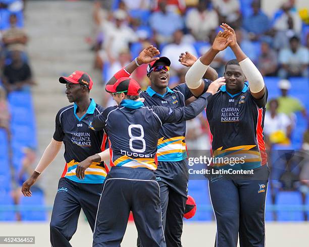 Rahkeem Cornwall of Antigua Hawksbills celebrates with Carlos Brathwaite and teammates the wicket of Kennar Lewis of The Red Steel during a match...