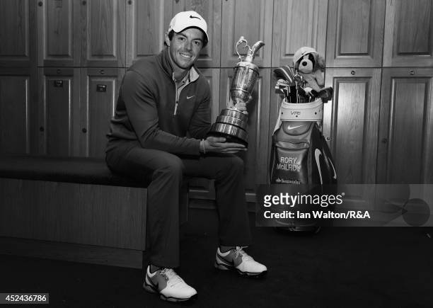 Rory McIlroy of Northern Ireland poses with the Claret Jug in the locker room after his two-stroke victory in The 143rd Open Championship at Royal...