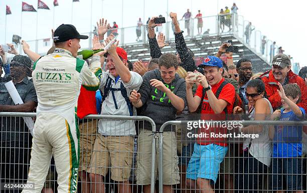 Mike Conway of England driver of the Ed Carpenter Racing Dallara Chevrolet winner, sprays champagne on the crowd at the podium ceremony during race 2...